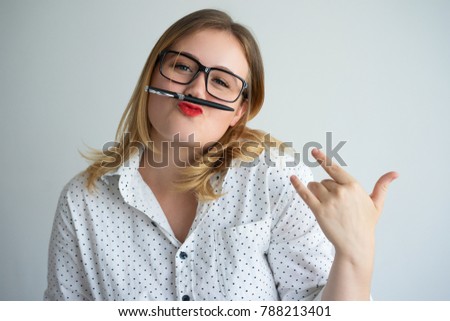 Funny playful young woman grimacing with pen