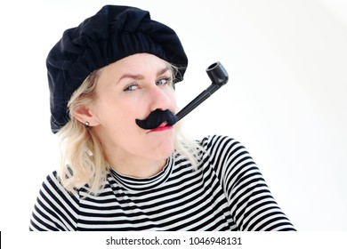 Funny Portrait Of Blond Woman As French Man With Beret, Mustache And Pipe