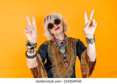 Funny portrait of mature woman. Beautiful lady have fun dressed with seventies costume. Mature woman on colored backgrounds - Shutterstock ID 2143549545