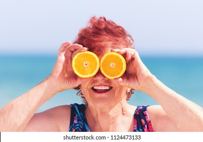 Funny Portrait Of Mature Woman, Grandma Having Fun With Orange Eyes On Summer Vacation