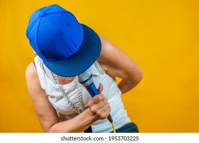 Funny Portrait Of Mature Woman. Lady Having Fun Dressed As An Angry Rapper. Mature Woman On Colored Backgrounds 