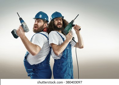 Funny portrait of two cheerful craftsmen - Shutterstock ID 380403097