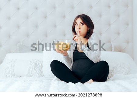Funny Pregnant Woman Eating Potato Chips in Secret . Mother to be hiding her guilty pleasure of eating salty junk food to cure morning sickness
