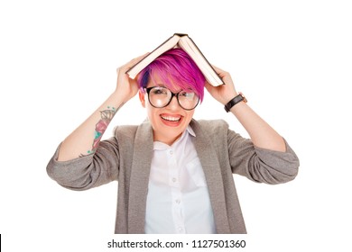 Funny pretty young woman wearing eyeglasses standing and laughing with book on her head as a roof isolated over white background. Positive face expression facial human emotion reaction. ADHD syndrome.