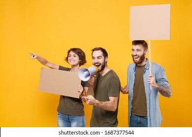 Funny protesting people guys girl hold protest signs broadsheet placard on stick scream in megaphone point aside isolated on yellow background. Protests strikes picket concept. Youth against city