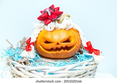 Funny pumpkin with braids and a bow in a basket. Jack's Lantern. Unusual Halloween, humor. 