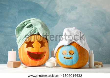 Funny pumpkins and skin care accessories on white background, copy space