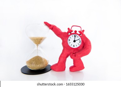 Funny Red Clock With Hourglass On White Table. Daylight Saving Time Concept.