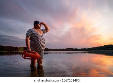 Funny retro lifeguard standing in the water and looking away with copy space 