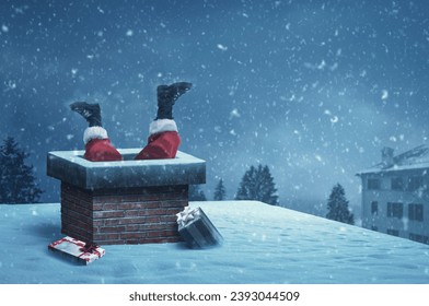 Funny Santa Claus stuck with feet up in a chimney on a roof, he is delivering gifts on Christmas Eve