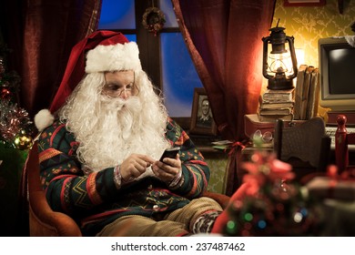 Funny Santa Claus using his new smartphone and relaxing at home - Powered by Shutterstock