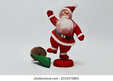 Funny Santa Claus waves his hand and stomps on the Christmas tree. Funny old style Christmas decoration isolated on white background.  - Powered by Shutterstock