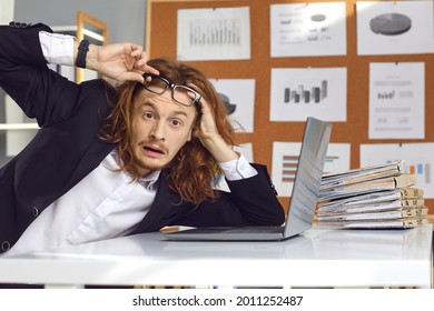 Funny Scared Shocked Unprepared For Crisis Business Man Or Office Worker Takes Off Glasses And Gasps In Surprise Sitting At Desk With Laptop. Money Trouble, Increasing Prices, Raising Taxes Concept