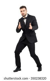 Funny Secret Agent Shooting At Camera With Handgun Pistol Finger Sign. Full Body Length Portrait Isolated Over White Studio Background.