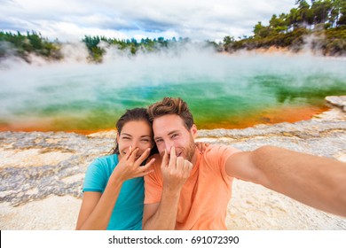 Funny Selfie Couple Tourists At New Zealand Pools Travel. Young People Doing Goofy Face At Smell Bad Sulfur Smell At Colorful Geothermal Hot Springs Ponds, Waiotapu.