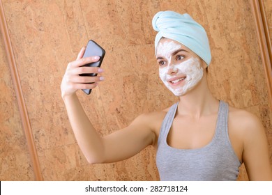 Funny Selfie. Girl Doing Selfie With White Clay Beauty Mask On Face. 