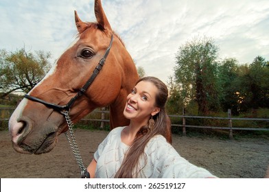 Funny selfie with my friend! Attractive smiling young woman holding camera and making selfie with her horse outdoors - Powered by Shutterstock