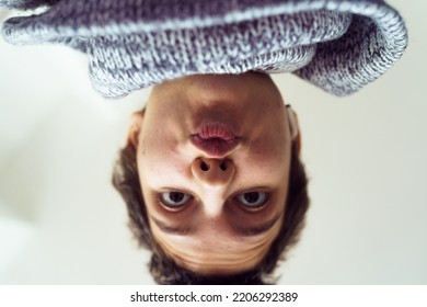 Funny selfie teenage girl with short haircut, upside down. Close up bottom up view of teenage girl happily enjoying moment, surprised posing for selfie, kissing with lips. Generation Z concept