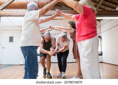 Funny senior dancers making arch with their arms for couple. Mature Caucasian partners walking under arch of joined hands in dance studio. Dance, hobby, healthy lifestyle concept - Powered by Shutterstock