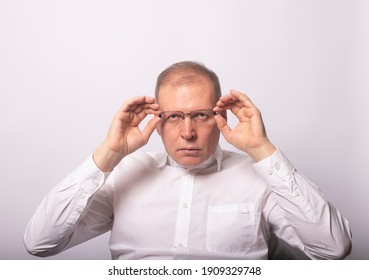 Funny serious man or businessman looking strictly while putting on glasses.