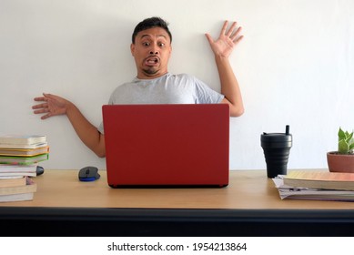 funny shocked man looking at laptop, surprised asian man with computer desk isolated in white, a guy bounce to wall after looking at laptop