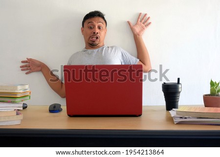 funny shocked man looking at laptop, surprised asian man with computer desk isolated in white, a guy bounce to wall after looking at laptop Stockfoto © 