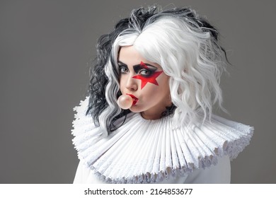 Une jeune femme amusante et choquante dans un maquillage brillant et avec une coiffure en noir et blanc. Étoile rouge sur l'oeil, style rock et roll mêlé à un style glamour