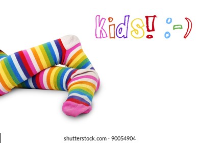 Funny shot of a little girl's crossed feet in very colorful striped socks or tights over white with kids and happy face symbols: perfect for anything relating to kids.