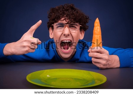 Funny silly guy eats carrots. Diet and healthy lifestyle.