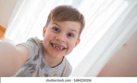 Funny Small Boy Taking Selfies And Grimacing. Smiling Cute Boy Taking Photos And Facetime Chatting. 