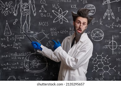 A funny smart scientist stands at the blackboard trying to explain scientific formulas and diagrams. Science and education.