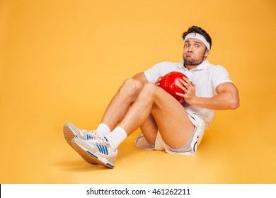 Funny Sports Man Working Out With Fitness Ball Isolated On A Orange Background