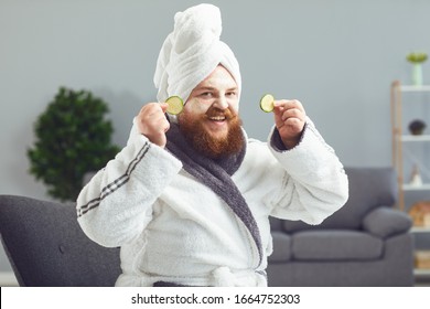 Funny Strange Fat Bearded Man With A Cosmetic Mask On His Face In A Bathrobe Does Spa Treatments On His Face Rests In A Room At Home