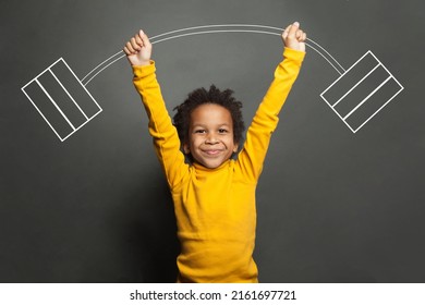 Funny Strong Black Kid With Barbell In Her Hands On Chalkboard Background