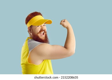 Funny Strong Fat Man Enjoying Fitness Exercises During His Workout At The Gym. Cheerful Excited Bearded Guy In A Yellow Sun Visor Showing His Arm And Smiling. Studio Shot, Side View