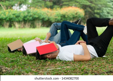 Funny students sleeping with books covering their face. Lazy and relaxation concept.