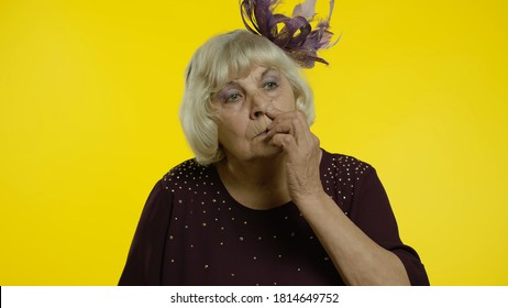 Funny Stupid Senior Old Woman Picking Nose With Silly Brainless Humorous Expression, Removing Boogers, Uncultured Habit, Bad Manners. Elderly Stylish Lady Grandma On Yellow Background