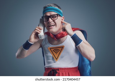 Funny Superhero Making A Phone Call Using An Old Obsolete Cordless Telephone, He Can't Hear The Caller