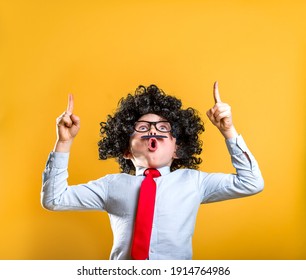 Funny Suprised Kid Primary Elementary School With Backpack Child With False Hair And Mustache In Uniform Pointing Fingers At Copy Space Advertising Products For Pupils Isolated On Yellow Background