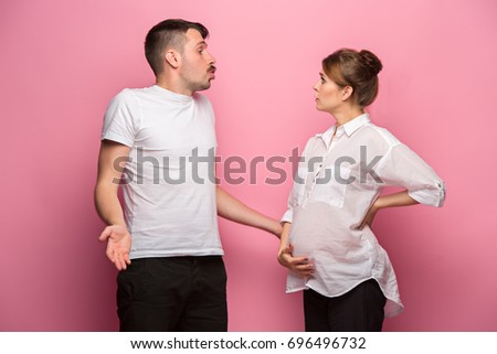 The funny surprised handsome man and his beautiful pregnant wife's tummy