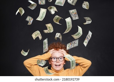 Funny Surprised Redhead Little Kid Boy In Glasses With Us Dollar Money Rain On Black Background