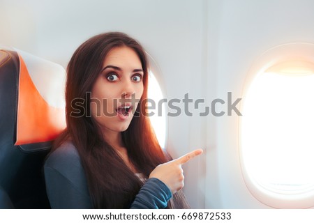 Funny Surprised Woman Sitting By the Window on An Airplane - Aircraft passenger feeling excited for the flight
