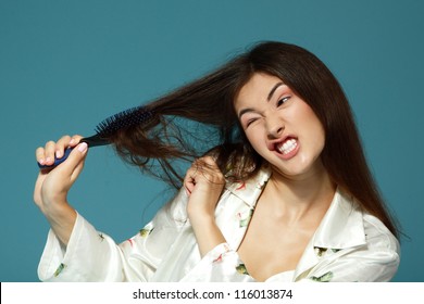 Funny Teen Girl Bombing Her Problem Hair In The Morning. Over Blue Background.