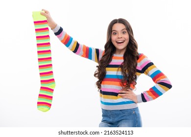 Funny teen hold strip sock on white background. Child holding a pair of stripped socks.