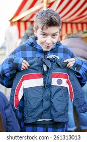 Funny Teenage Boy On A Flea Market Is Trying Too Small Dresses