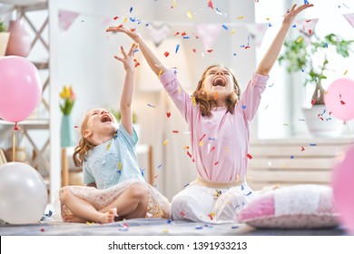 Funny Time. Children Are Playing At Home. Girls Are Throwing Confetti. Family Holiday And Togetherness.