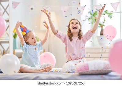 Funny Time. Children Are Playing At Home. Girls Are Throwing Confetti. Family Holiday And Togetherness.