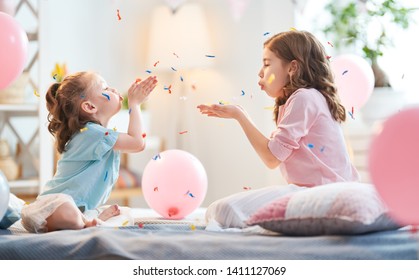 Funny Time. Children Are Playing At Home. Girls Are Throwing Confetti. Family Holiday And Togetherness.