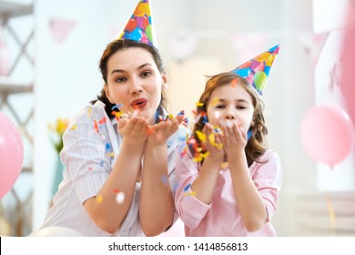 Funny Time. Mom And Her Child Daughter Are Playing At Home. Girls Are Throwing Confetti. Family Holiday And Togetherness.