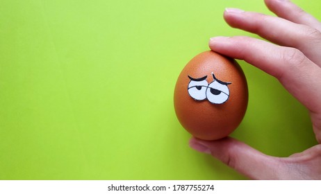 funny tired egg with eyes in a female hand on a green background - Shutterstock ID 1787755274
